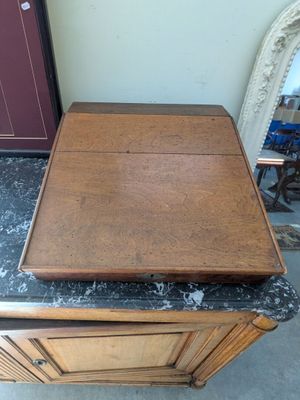 a small wooden table with a marble top on the floor