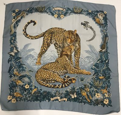 un gros plan sur une écharpe ornée d'un léopard et d'oiseaux