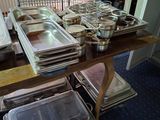 many trays of food on a table in the kitchen