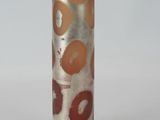 a silver vase with a brown and red design on it
