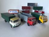Plusieurs camions miniatures sont alignés en rang sur une table