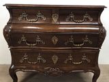 une commode ancienne ornée de sculptures raffinées sur le dessus