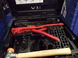 un outil dans une boîte à outils, à côté d'un marteau et d'une clé
