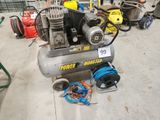 un petit compresseur d'air posé par terre à côté d'autres compresseurs d'air
