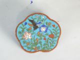 a blue plate with a bird and flowers on it