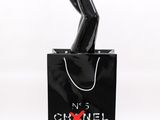 black chanel bag with a woman ' s legs sticking out of it