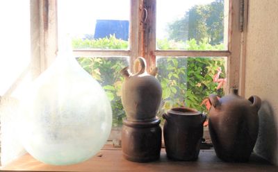 many vases sitting on a window sill in front of a window