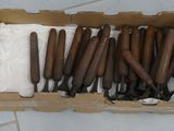 a cardboard box with a bunch of wooden handles in it