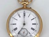 a gold pocket watch with roman numerals on it