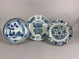 three blue and white plates with flowers on them