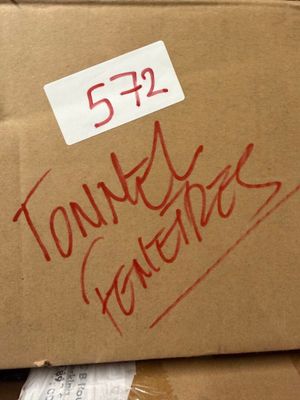 une boîte en carton sur laquelle est posée une pancarte, posée au sommet d'une pile de boîtes