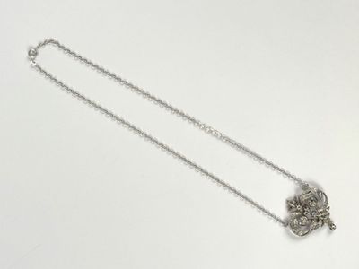 silver chain with a silver pendant on it on a white surface