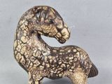 une figurine représentant un cheval posée sur une table