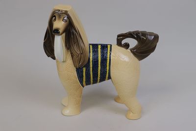 un petit chien en peluche qui porte un t-shirt bleu et jaune