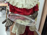 a statue of a woman holding a tray in a room
