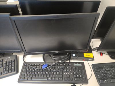 trois écrans d'ordinateur et un clavier posés sur un bureau