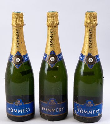 trois bouteilles de champagne sont alignées sur une surface blanche