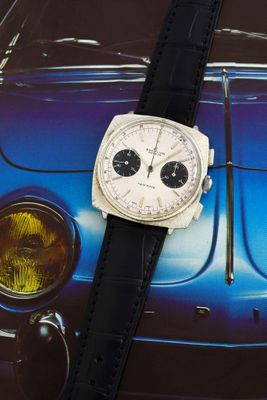 une montre posée sur une voiture, sur fond bleu