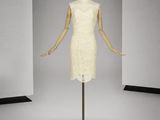 une photo d'un mannequin vêtu d'une robe blanche, posé sur un socle