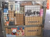 a metal cart with many boxes on it in a warehouse