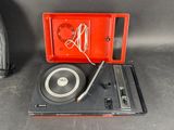 an old record player sitting on top of a red case