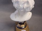 a white bust of a woman with a bird on it ' s head