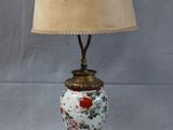 une image représentant une lampe posée sur une table, surmontée d'un abat-jour