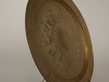 an image of a gold plate on a stand against a white background