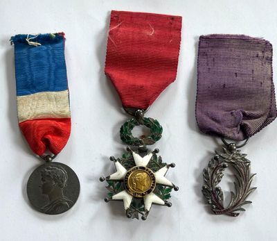 trois médailles et une médaille sur une surface blanche