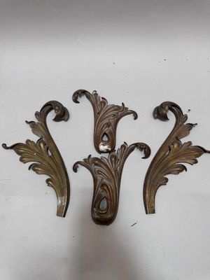 three antique brass wall hooks with ornate designs on them