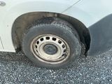 une camionnette blanche avec un pneu crevé sur la route