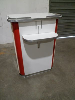 un comptoir blanc et rouge surmonté d'une étagère