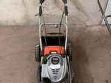 une tondeuse à gazon orange et noire garée dans un garage