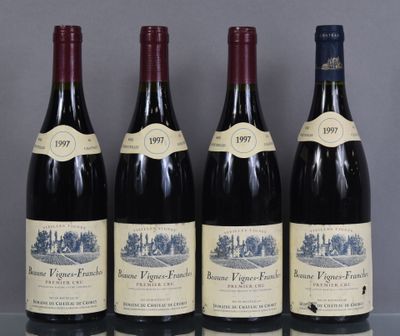 four bottles of wine are lined up on a table