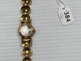 a close up of a gold bracelet with pearls on it