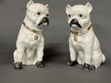 pair of white dog figurines with gold collars on grey background