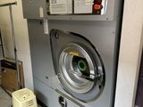 an image of a commercial washing machine in a laundry room