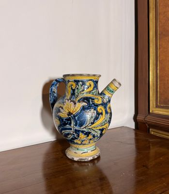 un vase bleu et jaune posé sur un parquet