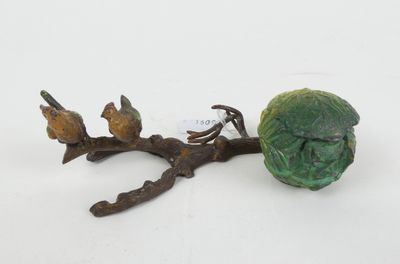une figurine représentant un chou et deux oiseaux perchés sur une branche