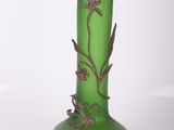 a green glass vase with a floral design on it
