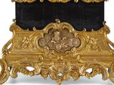 a gold and black marble clock on display on a stand