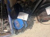 une boîte de vis et de chaînes posée par terre à côté d'une paire de chaussures