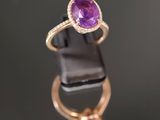 un gros plan d'une bague ornée d'un améthorate ovale entouré de diamants