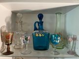 une étagère sur laquelle sont disposés de nombreux objets en verre