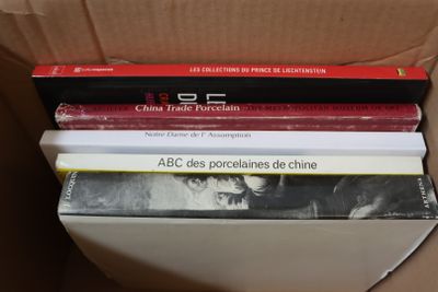 trois livres empilés les uns sur les autres dans une boîte en carton