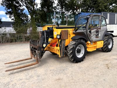 un petit tracteur garé sur un terrain en terre battue