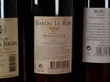 three bottles of wine are lined up on a shelf