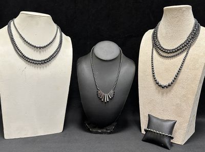 three mannequins with different types of necklaces on display