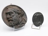 deux médaillons en bronze représentant un homme barbu et une pièce de monnaie