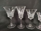 four crystal wine glasses are lined up on a black surface